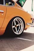 Vintage car gleaming under natural sunlight at an outdoor event.