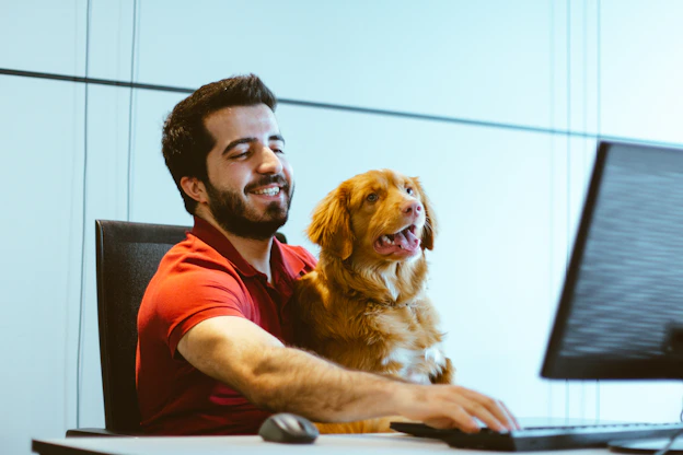 dog sitting on man's lap while using computer