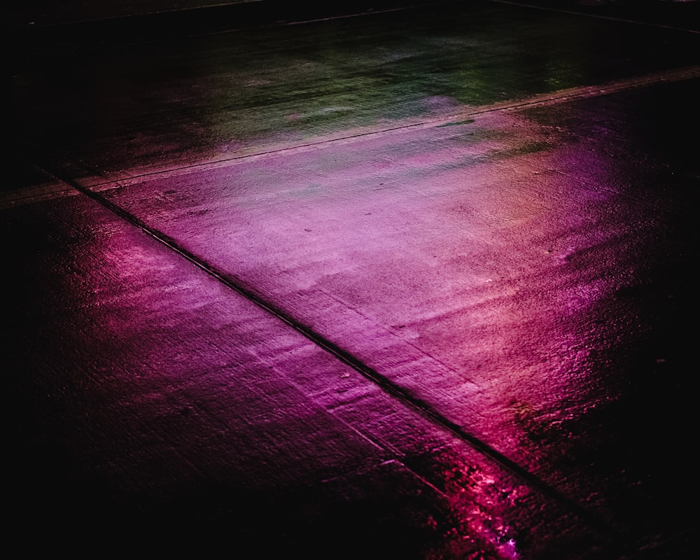 uma luz roxa brilha no chão no escuro