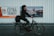 A blurred cyclist rides past two large advertisements on a metal wall. The left advertisement features a bold message about paprika chips being extra crunchy, with a color scheme of orange, black, and white. The right advertisement promotes a high-speed internet offer for Zurich, displaying a mix of blurred imagery and text.