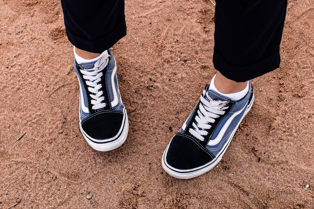 person wearing black-and-white Vans sneakers standing