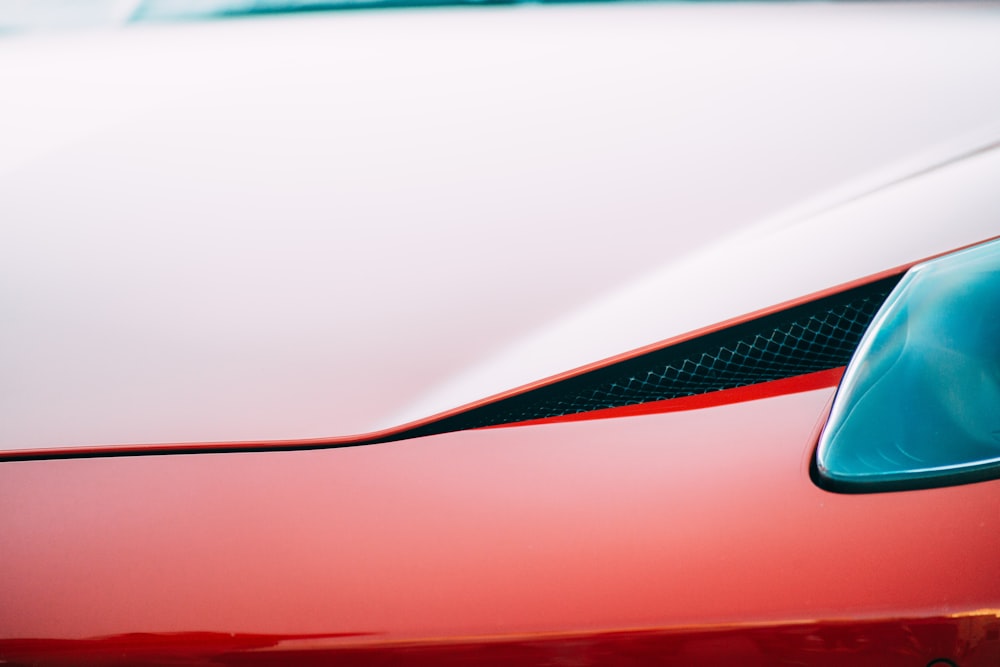 a close up of the hood of a red sports car