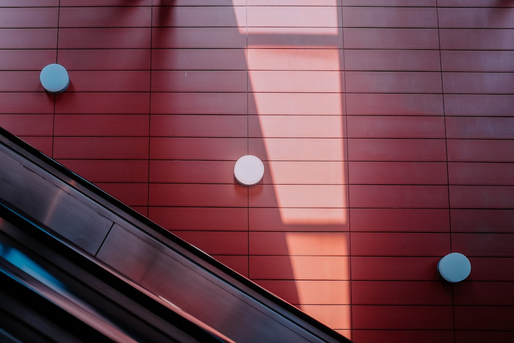 an escalator in front of a red building