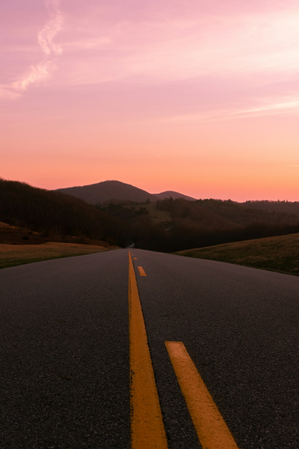 gray road near mountain during daytime