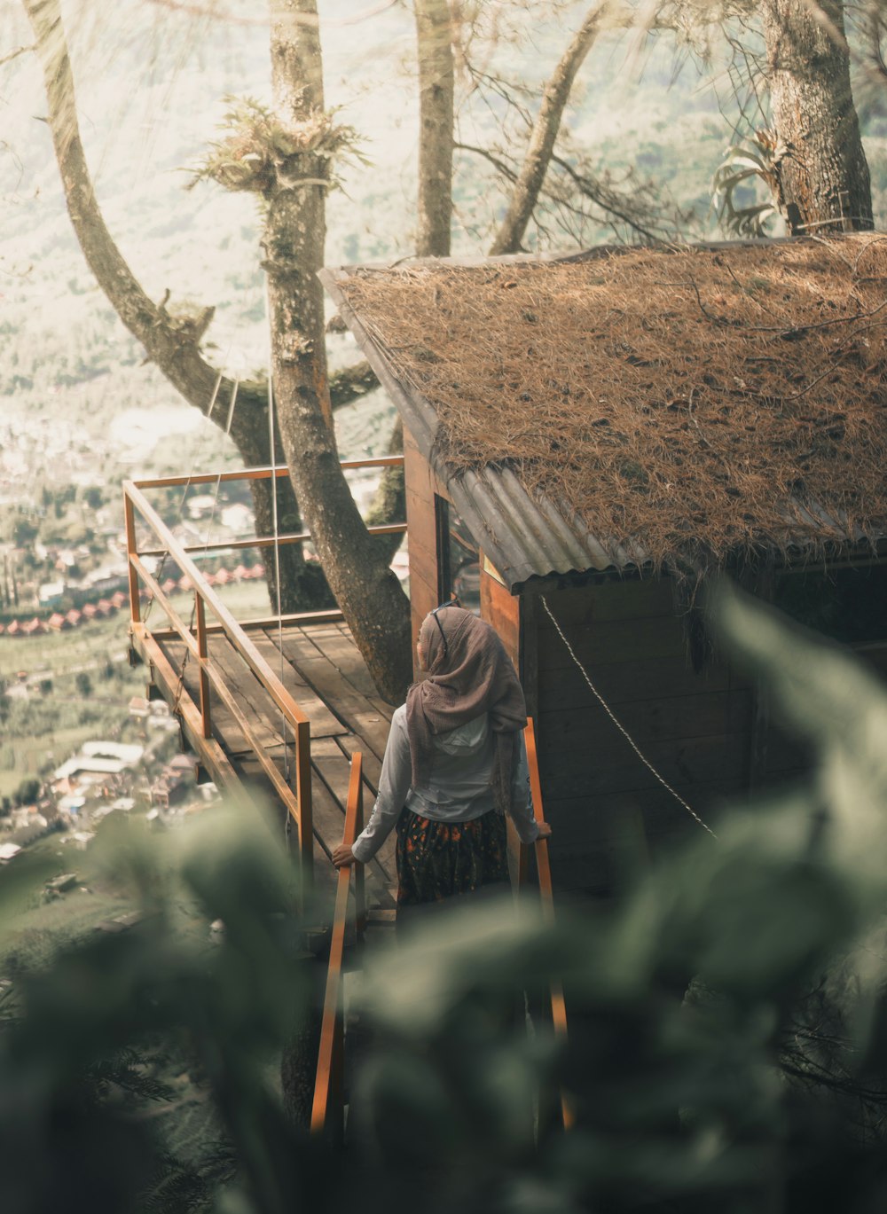 woman wearing hijab standing beside house