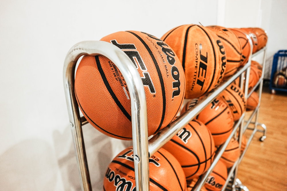 pile of basketballs beside wall