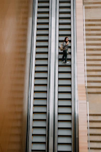 Senior smiling while safely using the elevita escalator on stairs.