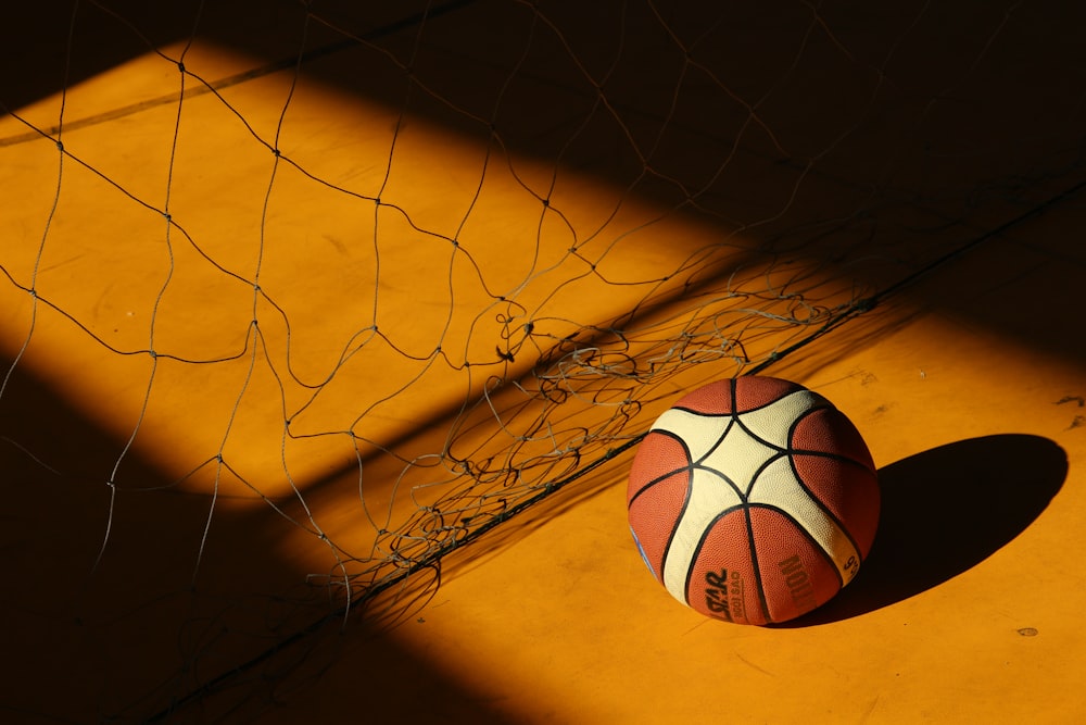 basketball near broken chain fence in dim light
