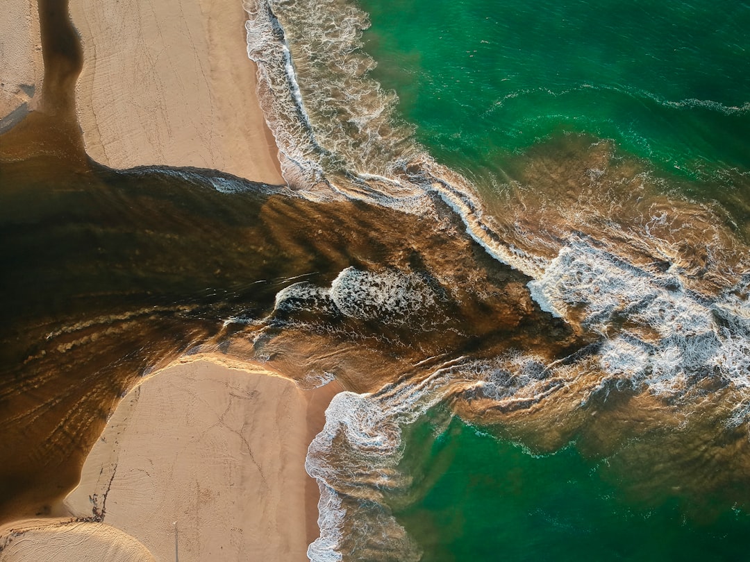 aerial photography of waves splashing on seashore