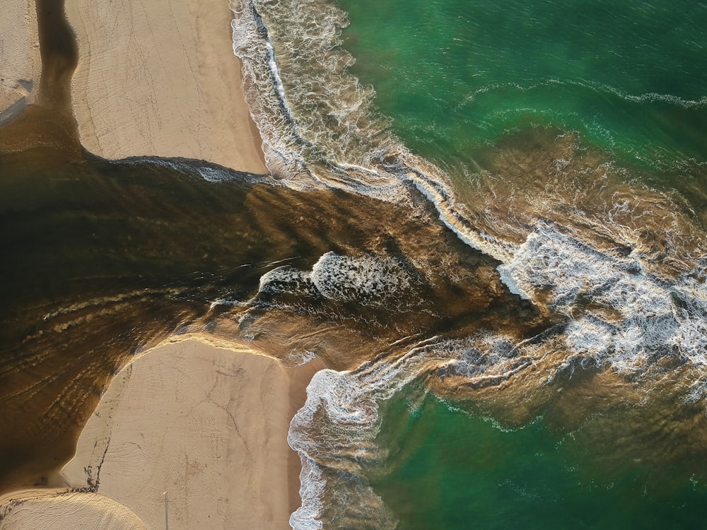 aerial photography of waves splashing on seashore