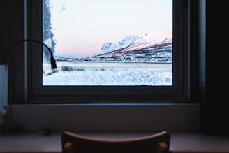 A serene classroom setting with large windows overlooking snowy Saint Moritz mountains.