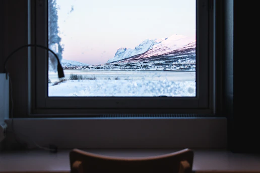 A serene classroom setting with large windows overlooking snowy Saint Moritz mountains.