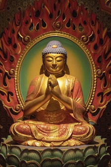 red and gold great buddha ceramic figurine in closeup photo