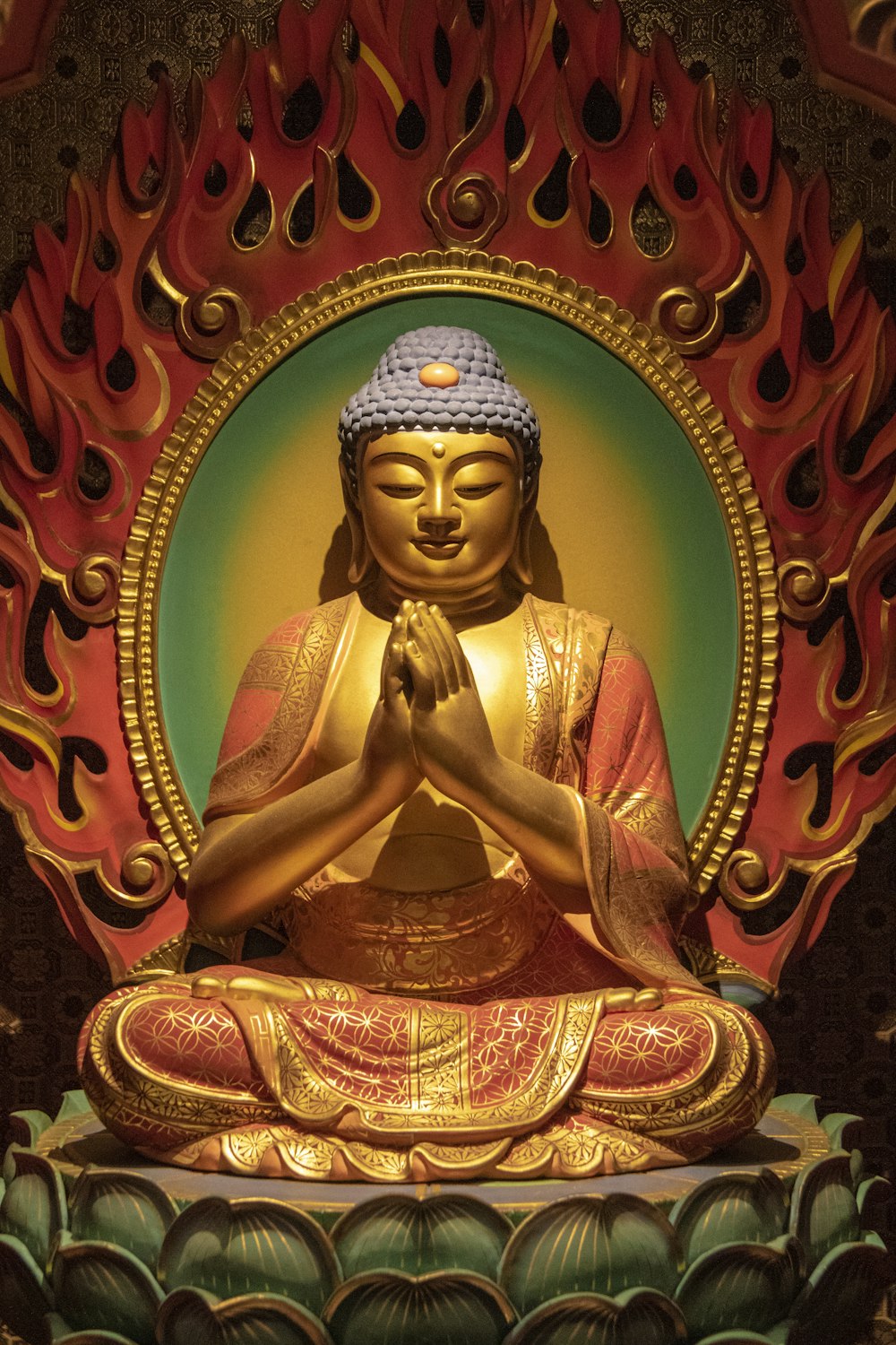 Figura de cerámica del Gran Buda rojo y dorado en la foto de primer plano