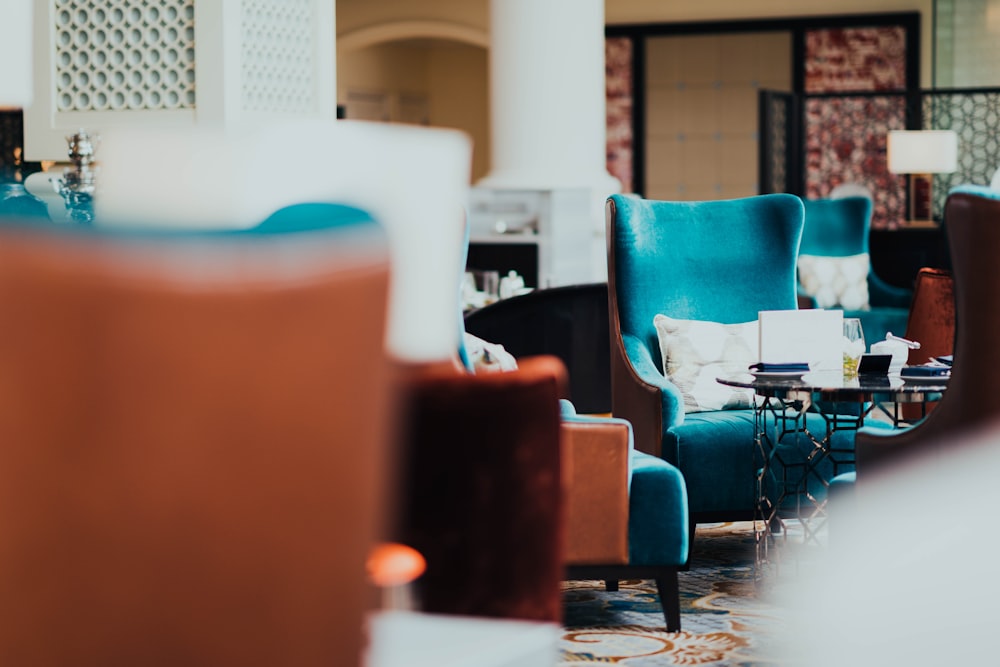 a living room filled with blue chairs and tables