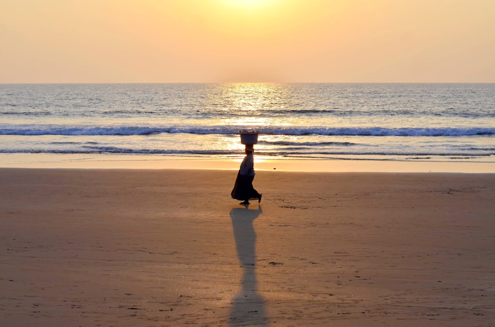 person walking on seashore during daytime