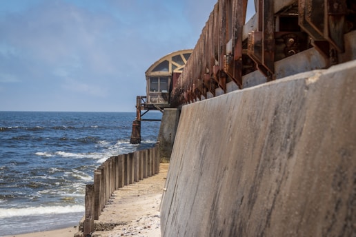 Construction workers building a sturdy sea defence wall along the coastline.