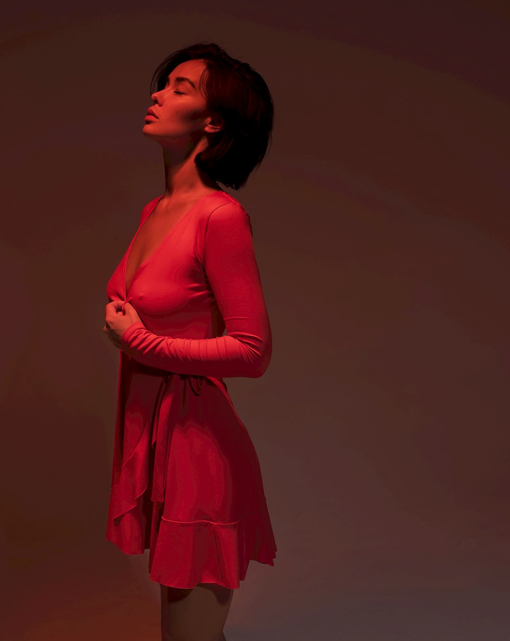 standing woman in pink long-sleeved dress