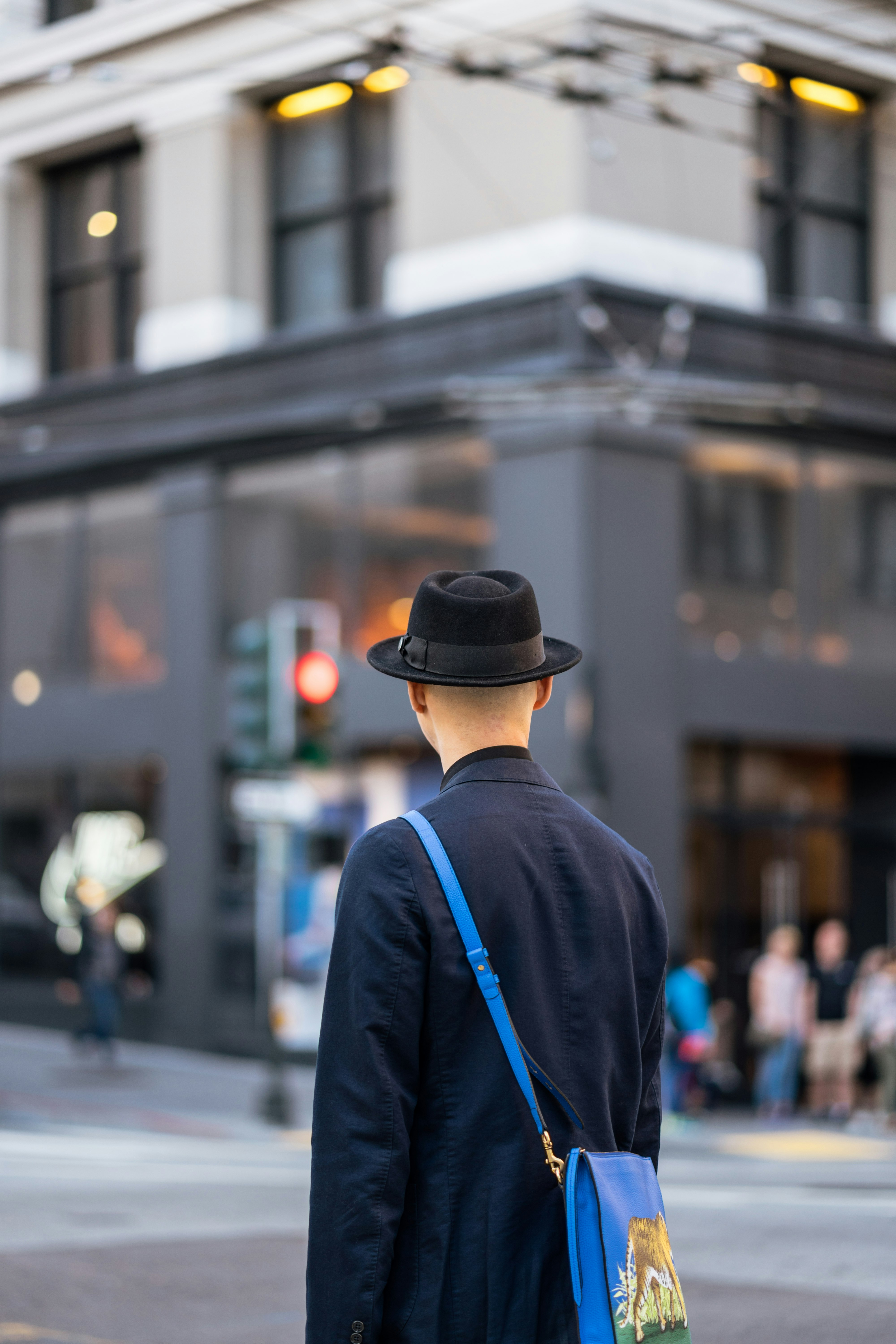 person wearing fedora hat and blue coat