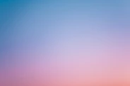 a pink and blue sky with a few clouds