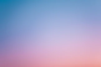 a pink and blue sky with a few clouds