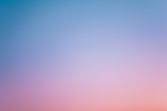 a pink and blue sky with a few clouds