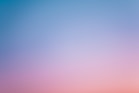 a pink and blue sky with a few clouds