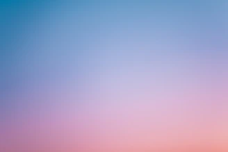 a pink and blue sky with a few clouds