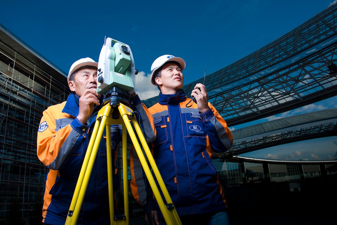 2 men in white hard hat holding a machine