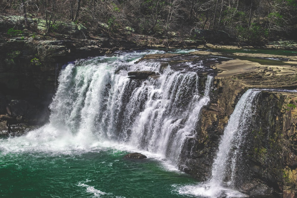 waterfalls near trees at daytime