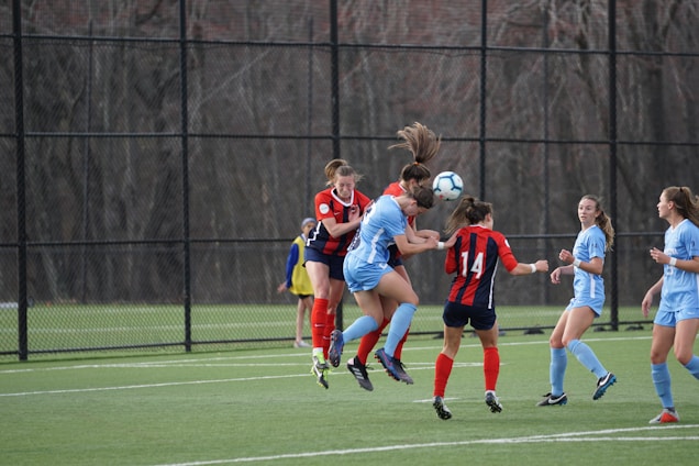 A vibrant soccer match scene with players in blue and red jerseys competing passionately on a sunny field.