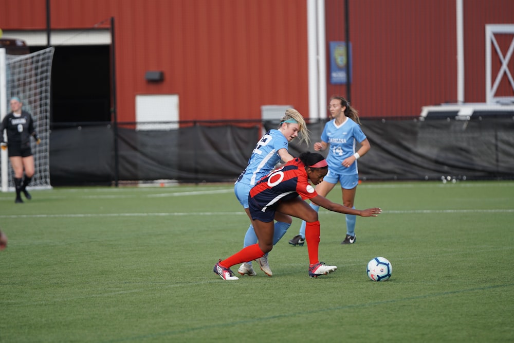 people playing soccer on field at daytime