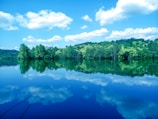 A serene landscape with a tranquil lake reflecting the sky.