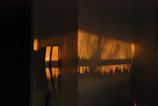Still frame of a vertical branded content video featuring vibrant warm light accents against a charcoal background.