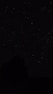 the night sky with stars above a mountain