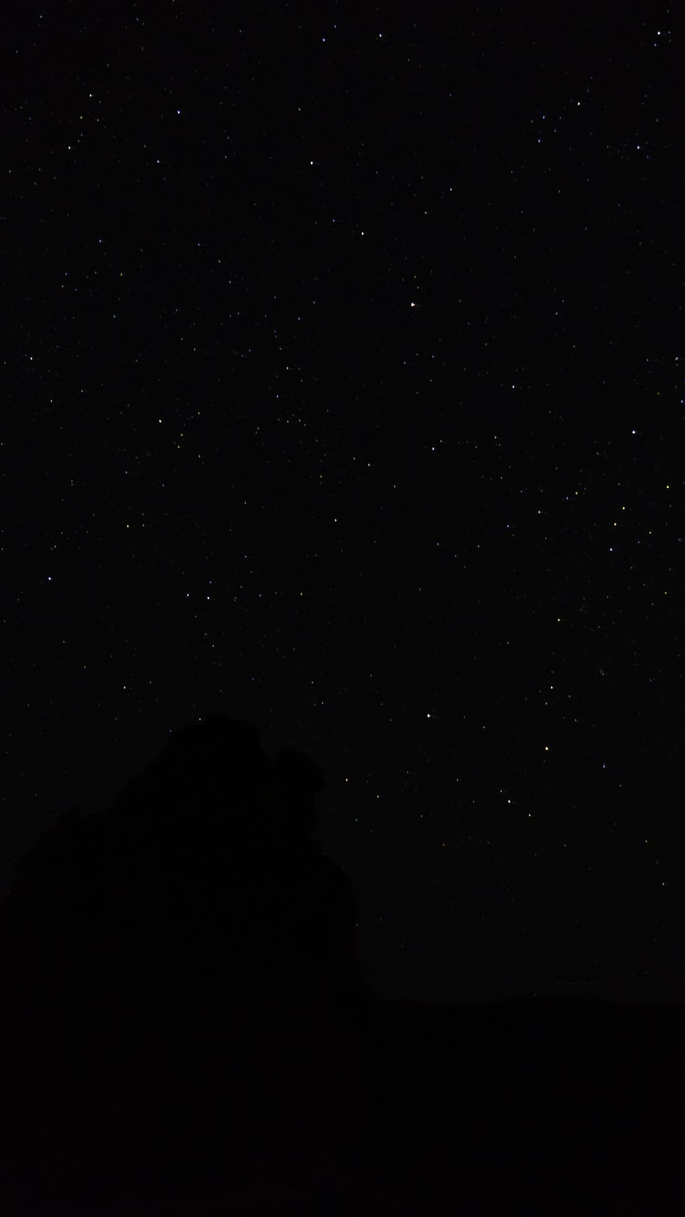 O céu noturno com estrelas acima de uma montanha