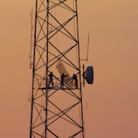 three people standing on crane tower