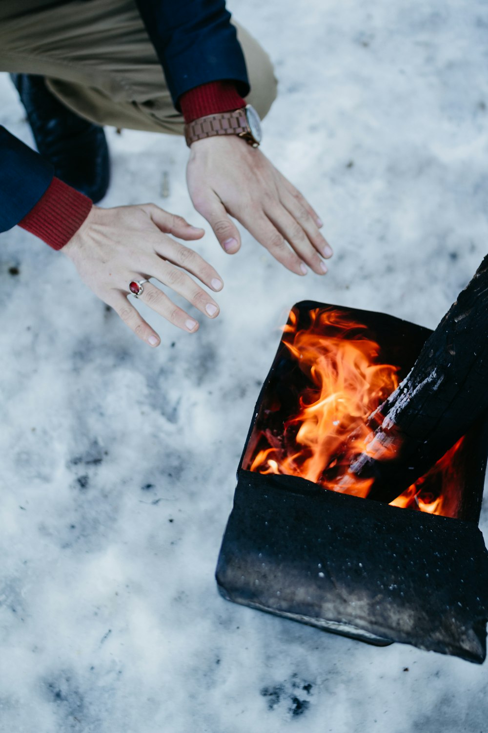 Person, die Hände am Feuer wärmt