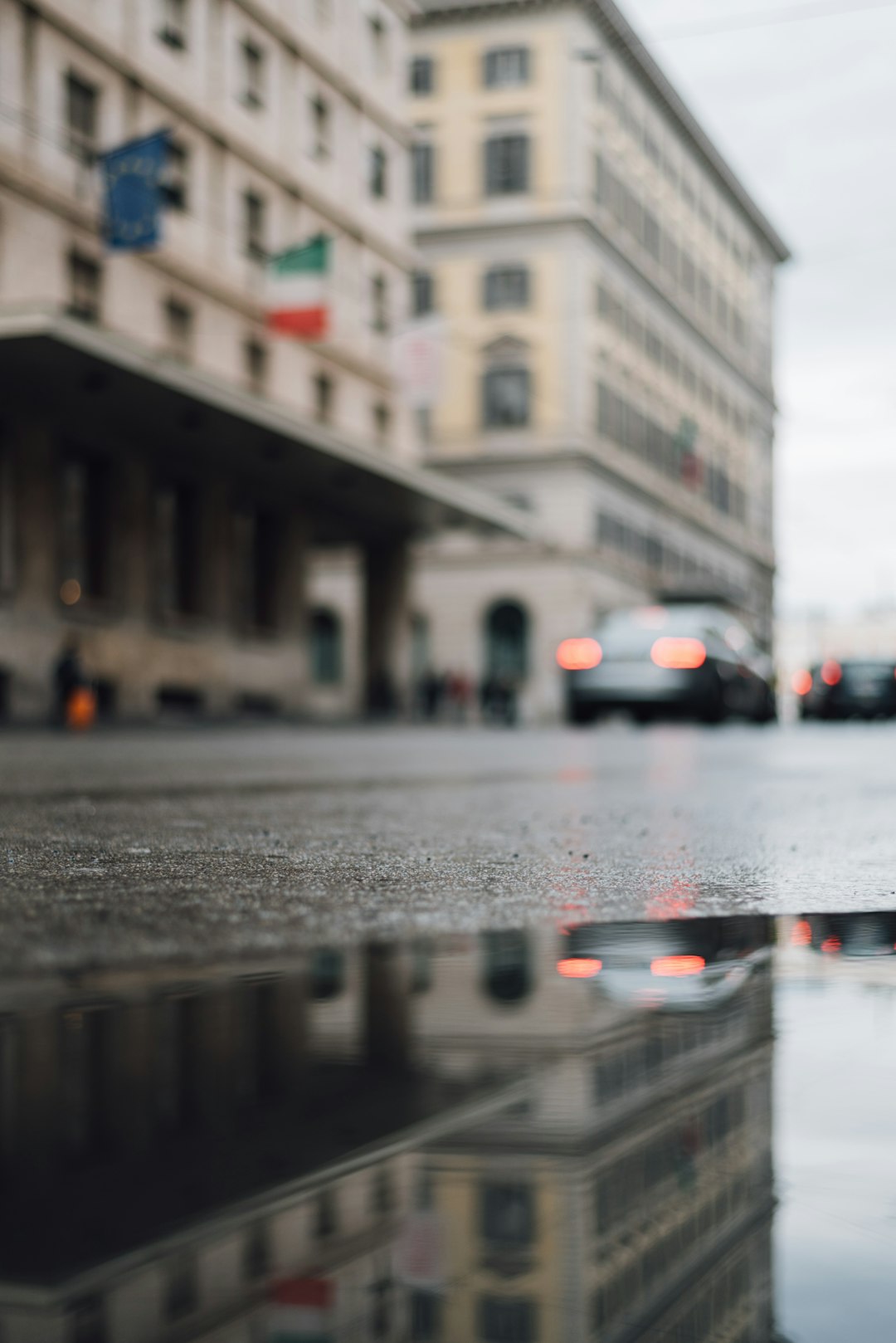 water puddle on road near concrete high-rise buildings