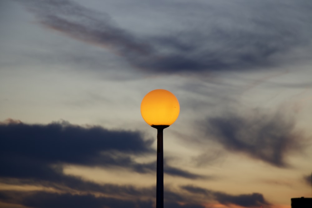 a street light with a cloudy sky in the background