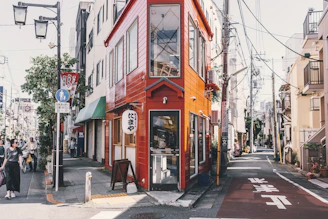 A vibrant street scene showing neighbors sharing smiles outside a local store painted in red, black, and shining silver.