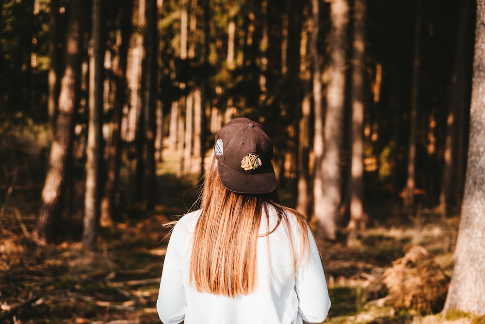 person wearing black cap standing in jungle