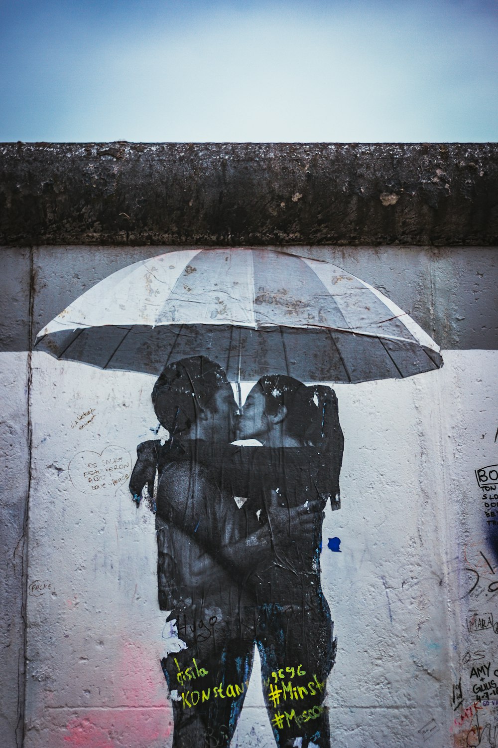 man and woman kissing under umbrella photo
