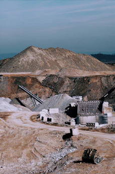 Industrial limestone quarry with heavy machinery extracting raw materials under a clear sky.