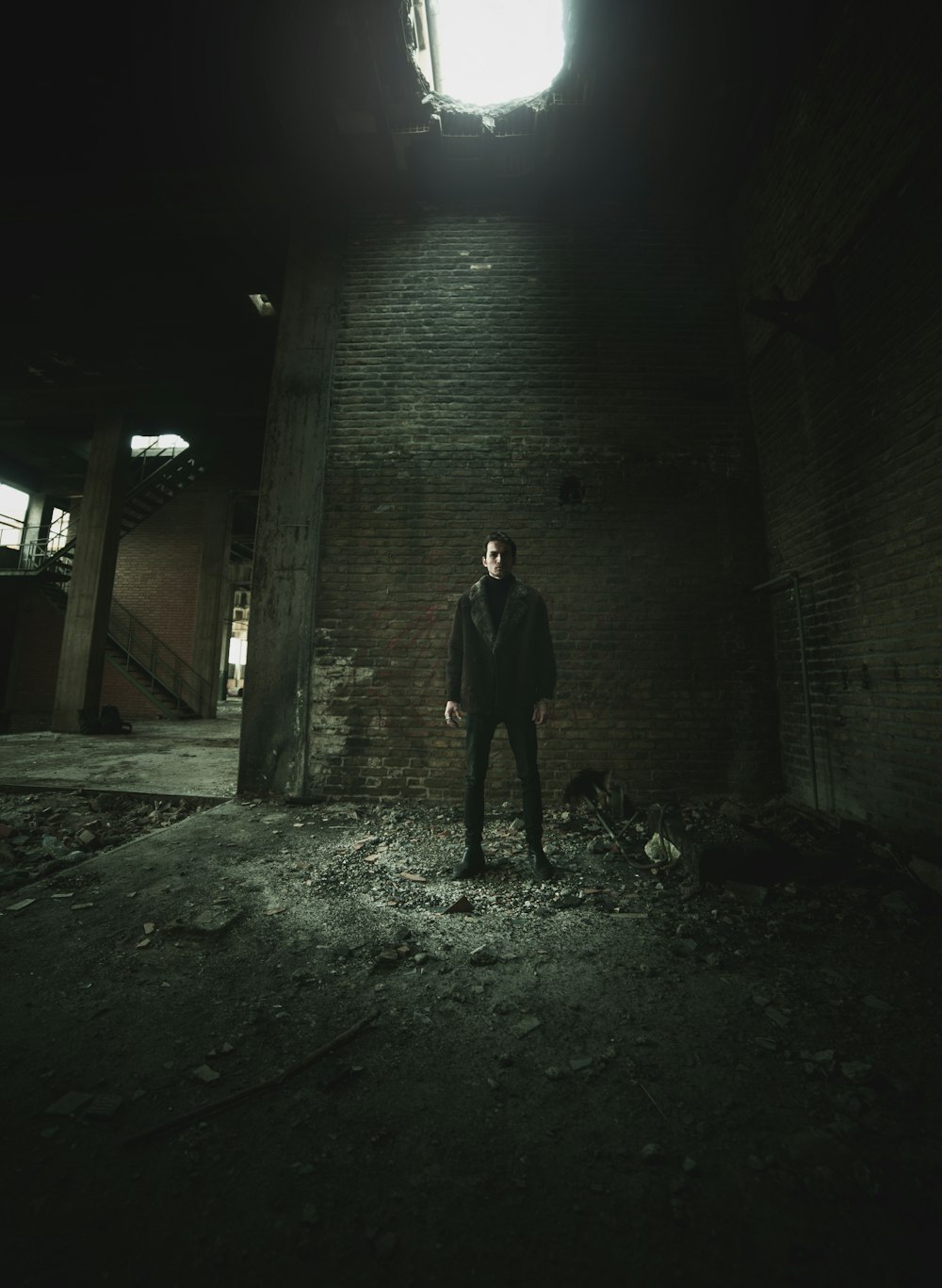 man standing near brick wall