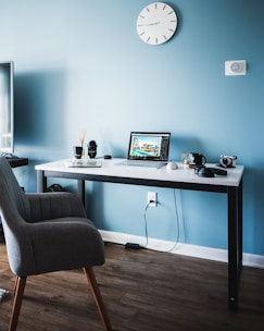 Architectural blueprints and a laptop on a wooden desk.