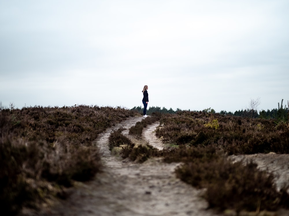 person standing on dirt path