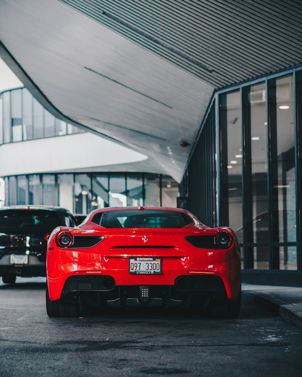 red sports coupe near building