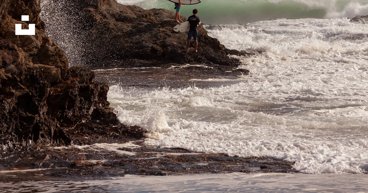 Surfers on rock photo – Free Grey Image on Unsplash