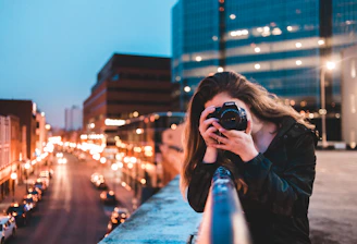 woman using black camera outdoors